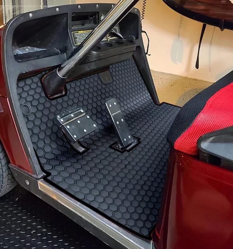Interior of a golf cart with black honeycomb floor mat and pedals