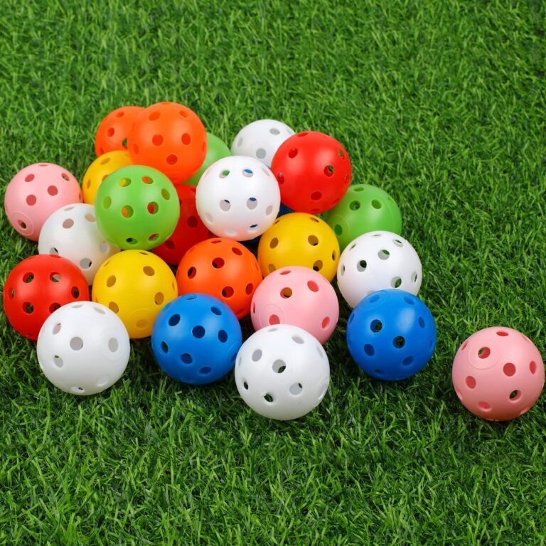 Colorful plastic balls with holes on green artificial grass